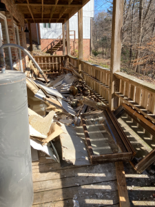 Damaged porch with debris and construction materials