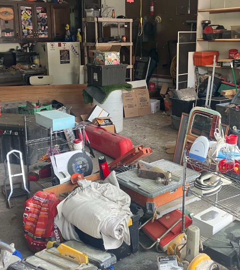 Cluttered room with various household items and moving boxes ready for transport