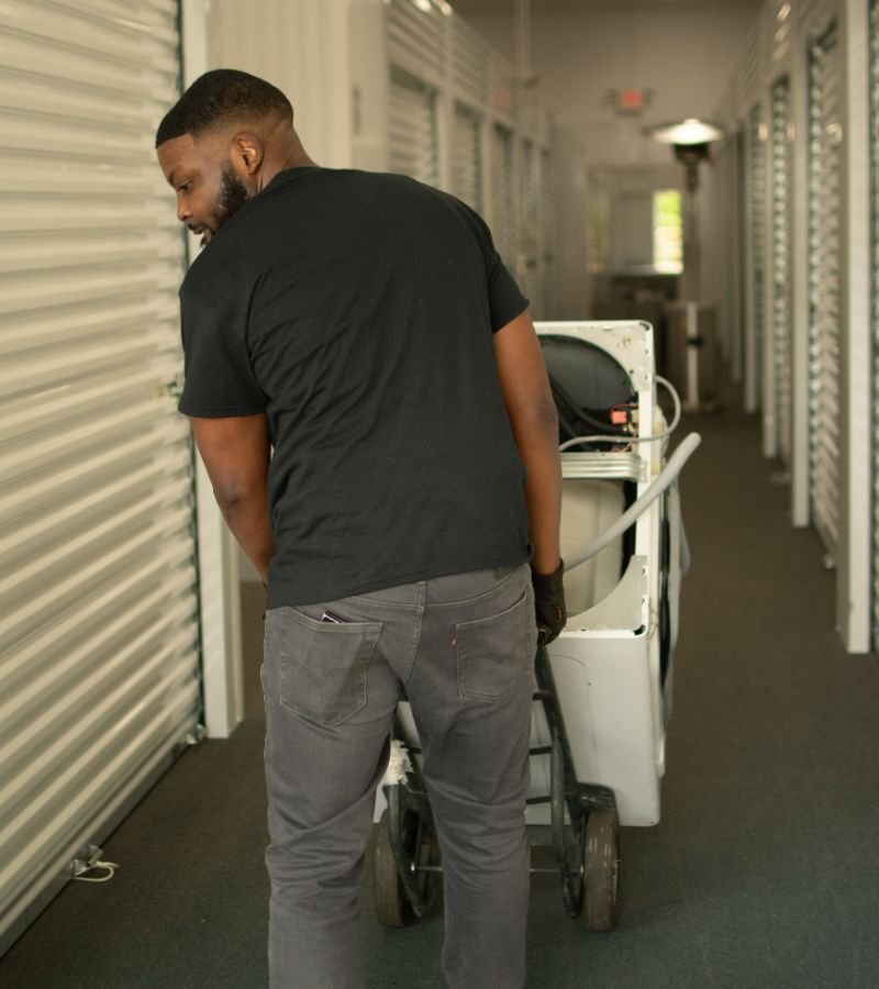 Man moving a dolly with boxes in a storage facility