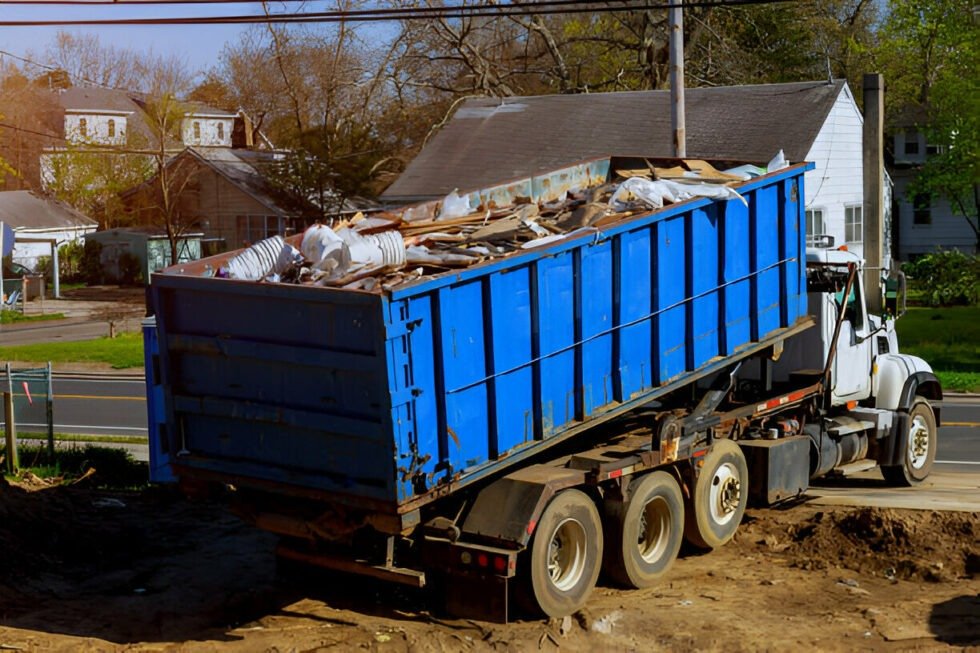 Blue dumpster truck filled with debris, ideal for spring cleaning and junk removal services.
